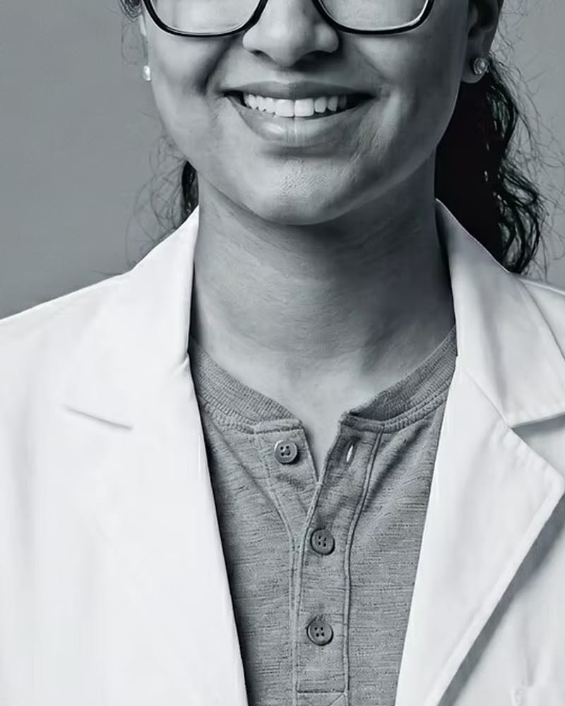 Dr. Jasmeet Kaur, D.D.S., in a white coat at Radiant Smiles.
