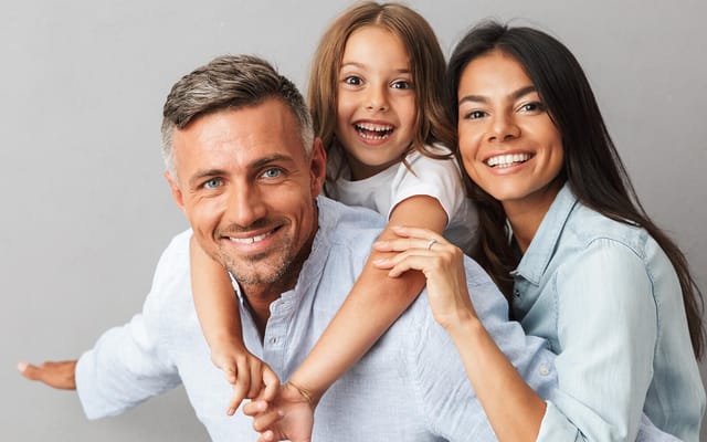 A family smiling together — the subject of Radiant Smiles' family dentistry.