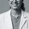 Dr. Jasmeet Kaur, D.D.S., in a white coat at Radiant Smiles.
